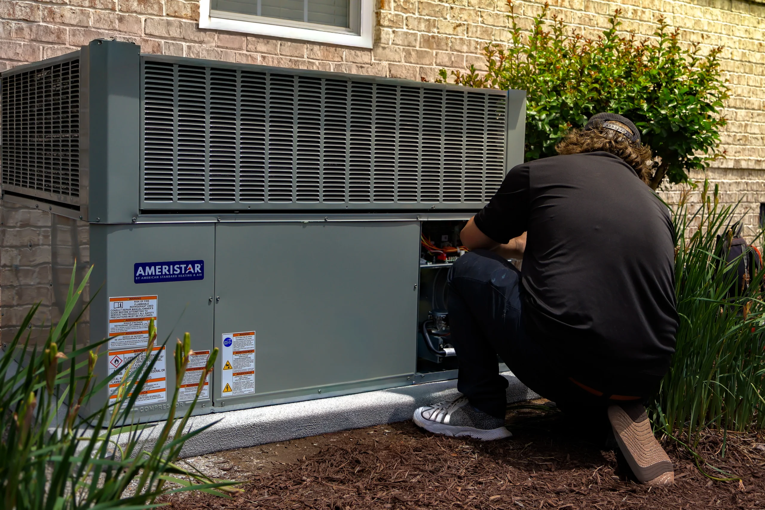 An HVAC technician works on a unit
