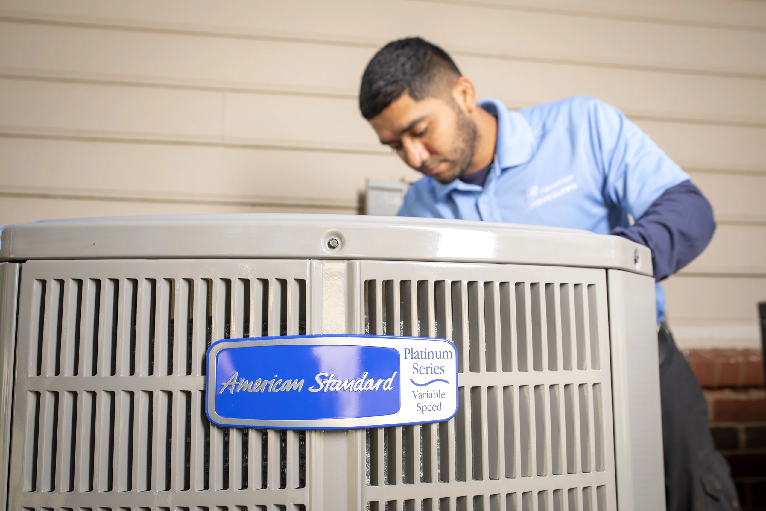 and HVAC technician inspects a newly installed American Standard unit.